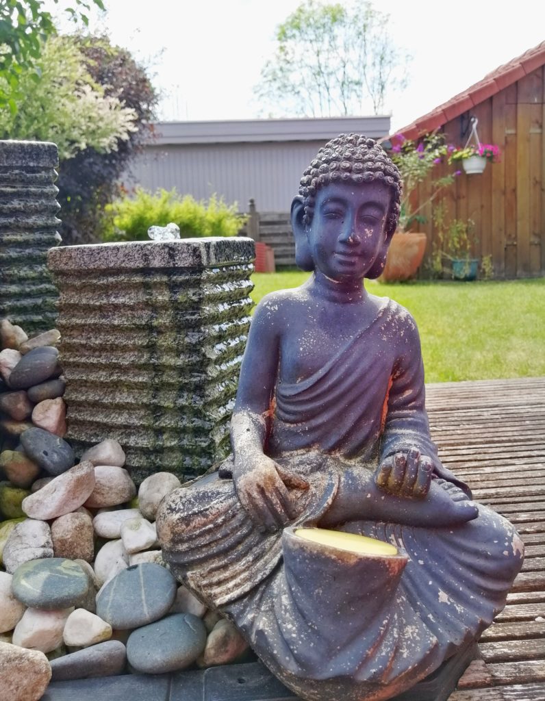 Achtsamkeitsübungen im GArten - Meditierende Figur an Brunnen